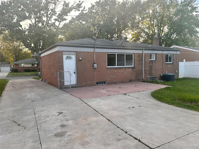 26304 Patricia Ave, Sterling Heights, MI 48091 - back of house featuring central air condition unit, brick siding, a chimney, and a patio area