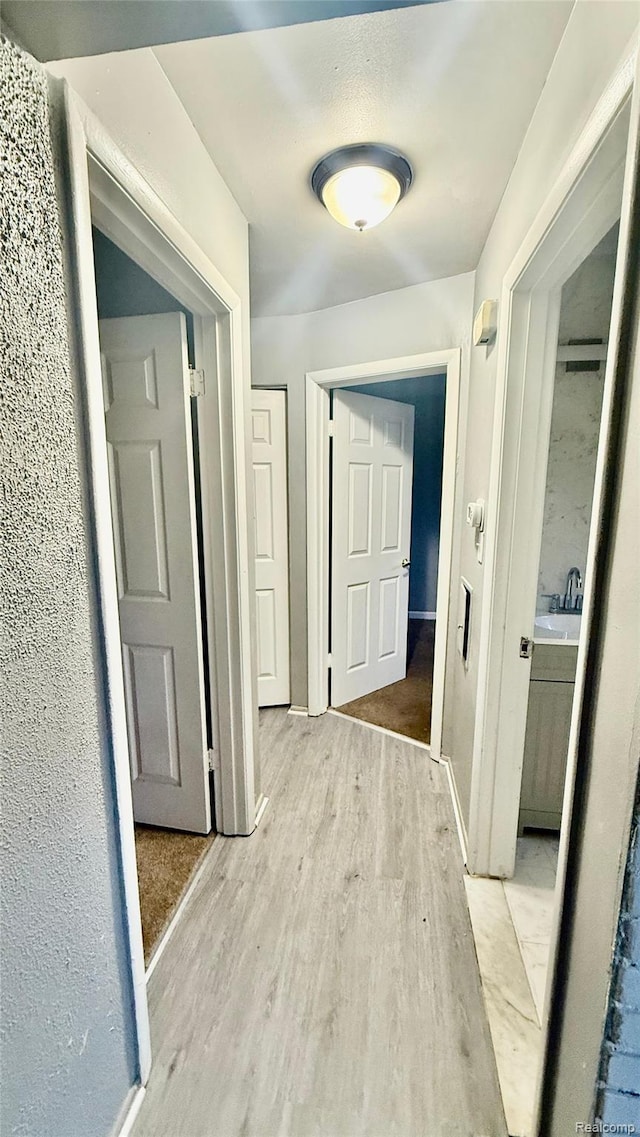 26304 Patricia Ave, Sterling Heights, MI 48091 - hallway with light wood-type flooring and a sink