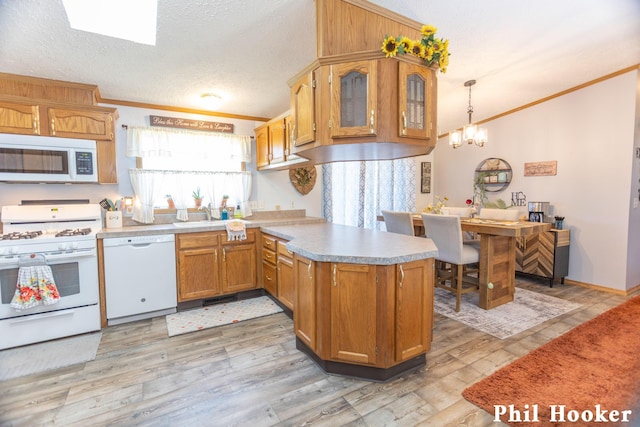 105 Penny Ln, Stanton, MI 48888 - kitchen featuring white appliances, a peninsula, crown molding, light countertops, and light wood-style flooring