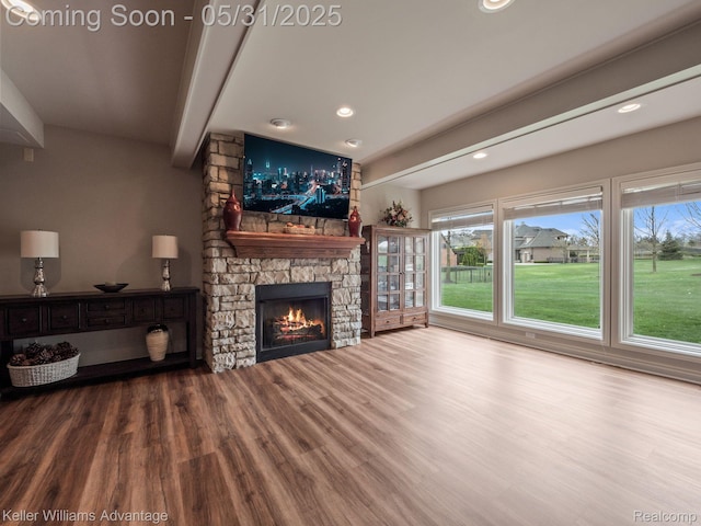 20971 Pomino Dr, Northville, MI 48167 - unfurnished living room featuring beamed ceiling, wood finished floors, a stone fireplace, and recessed lighting