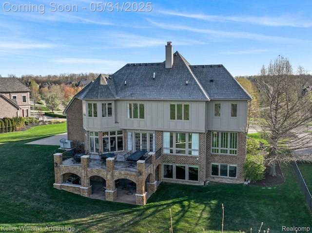 20971 Pomino Dr, Northville, MI 48167 - back of property featuring board and batten siding, a chimney, a yard, and a patio