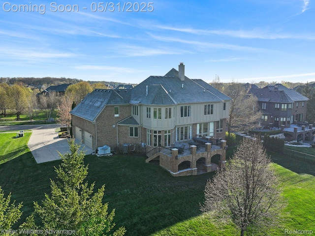20971 Pomino Dr, Northville, MI 48167 - view of side of property with a chimney, driveway, a garage, and a lawn