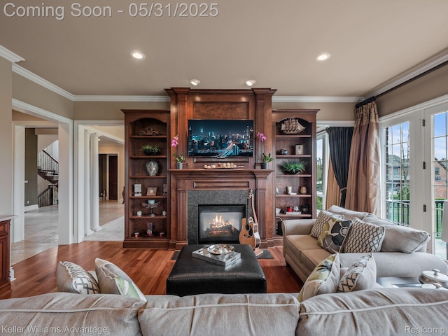 20971 Pomino Dr, Northville, MI 48167 - living area with ornamental molding, a glass covered fireplace, stairway, wood finished floors, and recessed lighting