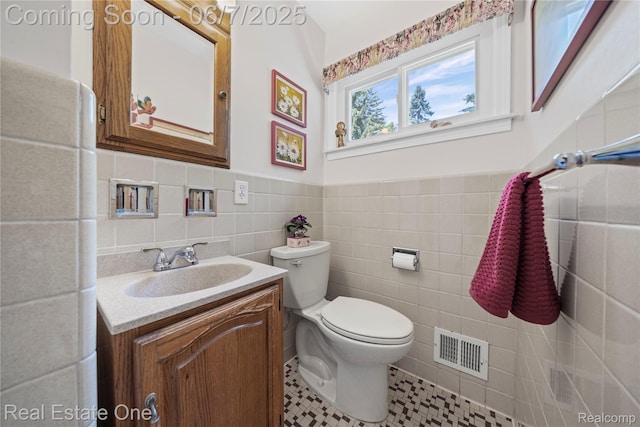 2253 Robell Dr, Commerce Twp, MI 48390 - bathroom with tile walls, toilet, vanity, a wainscoted wall, and tile patterned flooring