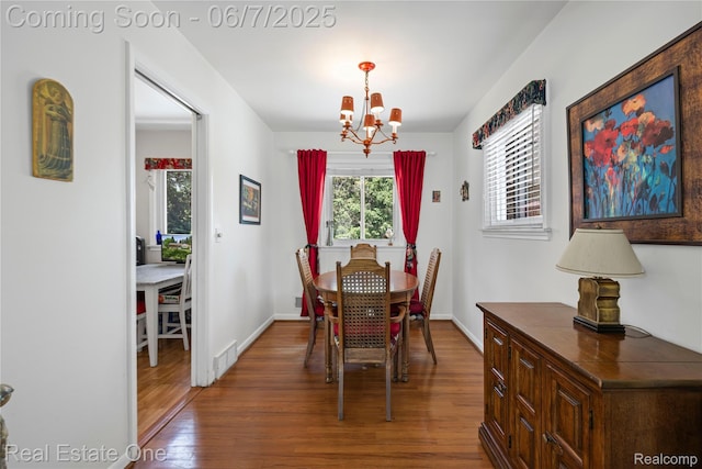 2253 Robell Dr, Commerce Twp, MI 48390 - dining room featuring wood finished floors, a chandelier, and baseboards