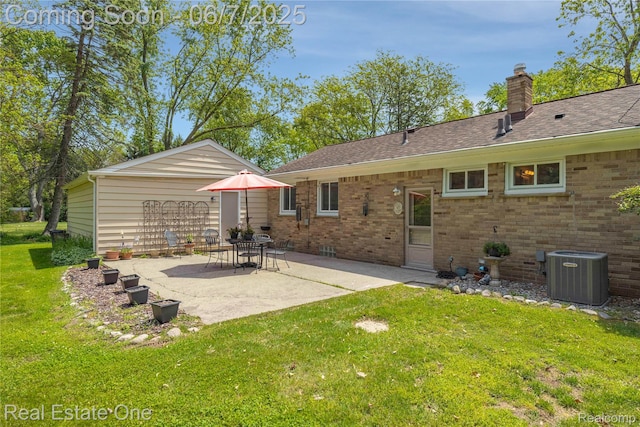 2253 Robell Dr, Commerce Twp, MI 48390 - back of property featuring central air condition unit, a lawn, a patio, a chimney, and brick siding
