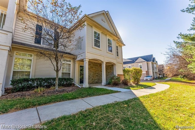 16211 Addington Dr Unit 192, Commerce Twp, MI 48390 - view of front of home featuring a front yard and stone siding