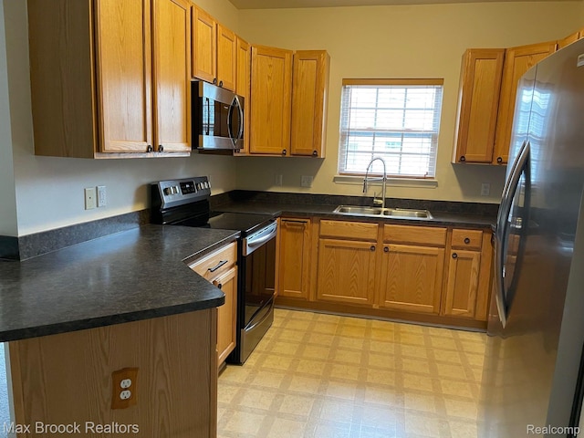 16211 Addington Dr Unit 192, Commerce Twp, MI 48390 - kitchen with appliances with stainless steel finishes, a sink, light flooring, dark countertops, and brown cabinets