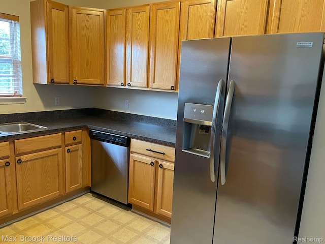 16211 Addington Dr Unit 192, Commerce Twp, MI 48390 - kitchen featuring stainless steel appliances, dark countertops, light floors, and a sink