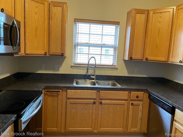 16211 Addington Dr Unit 192, Commerce Twp, MI 48390 - kitchen with appliances with stainless steel finishes, a sink, dark countertops, and brown cabinetry
