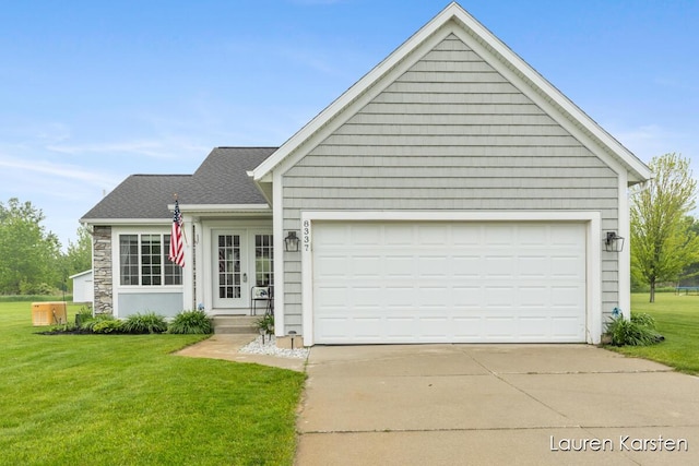 8337 Pebble Dr NE, Rockford, MI 49341 - view of front facade featuring a front lawn, french doors, driveway, and an attached garage