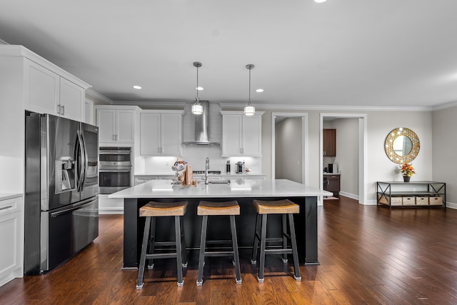 2349 Westbrooke Ct, Ann Arbor, MI 48105 - kitchen featuring stainless steel appliances, wall chimney range hood, light countertops, a kitchen breakfast bar, and crown molding