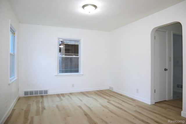 15243 Eastwood St, Detroit, MI 48205 - unfurnished room with arched walkways, wood finished floors, and baseboards