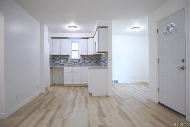 15243 Eastwood St, Detroit, MI 48205 - kitchen featuring tasteful backsplash, light wood-style flooring, light countertops, and white cabinets