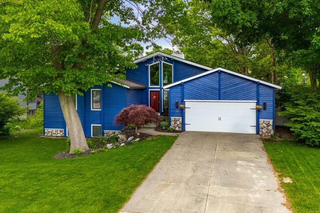 6767 Knollview Dr, Hudsonville, MI 49426 - view of front of property featuring a front yard, driveway, a garage, and stone siding