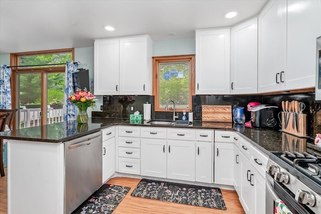 6767 Knollview Dr, Hudsonville, MI 49426 - kitchen with stainless steel appliances, a peninsula, a sink, light wood-type flooring, and white cabinetry