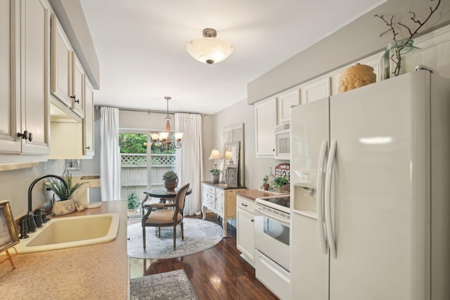 133 Commons Cir, Saline, MI 48176 - kitchen with white appliances, a sink, a chandelier, dark wood finished floors, and pendant lighting