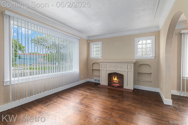 5025 Somerset Ave, Detroit, MI 48224 - unfurnished living room with arched walkways, wood finished floors, a fireplace with flush hearth, a textured ceiling, and baseboards