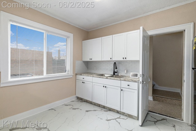 5025 Somerset Ave, Detroit, MI 48224 - kitchen with a sink, tasteful backsplash, baseboards, white cabinets, and light marble finish floors