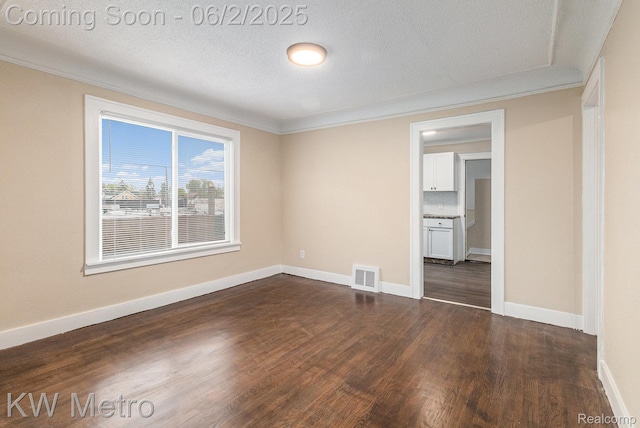 5025 Somerset Ave, Detroit, MI 48224 - spare room featuring dark wood-style flooring, ornamental molding, baseboards, and a textured ceiling