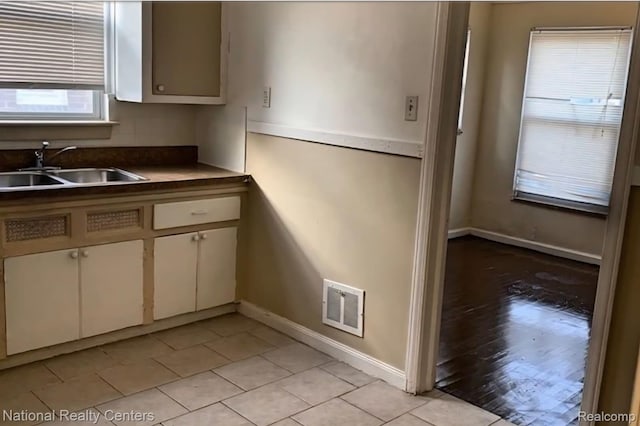8227 Coyle St, Detroit, MI 48228 - kitchen featuring a sink, baseboards, light tile patterned floors, and dark countertops