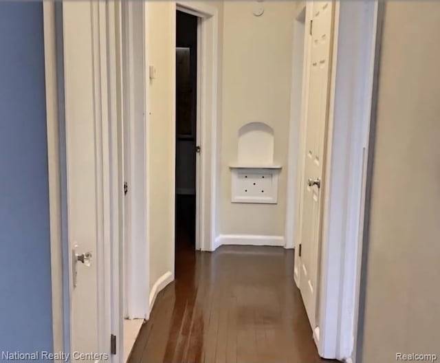 8227 Coyle St, Detroit, MI 48228 - hallway featuring dark wood finished floors and baseboards