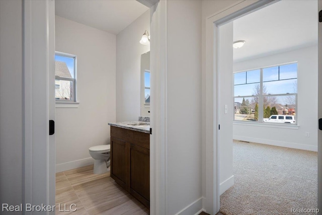 35704 Addison Dr, New Baltimore, MI 48047 - bathroom with vanity, baseboards, toilet, and plenty of natural light