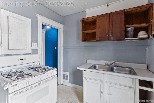 5839 Mcmillan St, Allen Park, MI 48209 - kitchen featuring white gas range oven, open shelves, a sink, light countertops, and baseboards