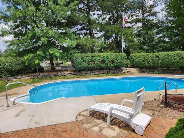 3313 Gethings Rd, Battle Creek, MI 49015 - view of swimming pool featuring a fenced backyard, view of wooded area, and a diving board