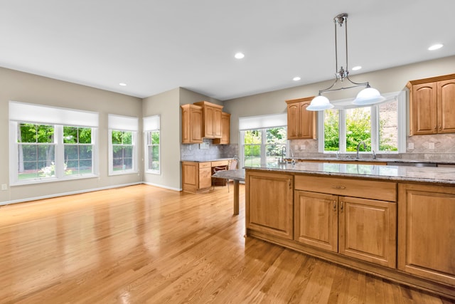482 Torrington Dr W, Canton, MI 48188 - kitchen featuring backsplash, light wood-style flooring, light stone countertops, decorative light fixtures, and recessed lighting
