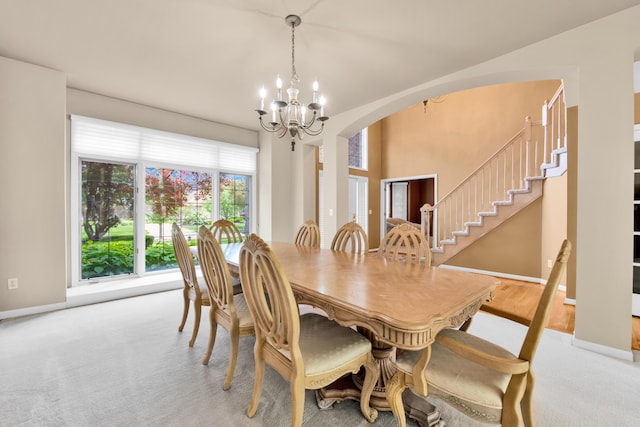 482 Torrington Dr W, Canton, MI 48188 - dining area with a chandelier, arched walkways, baseboards, carpet, and stairs