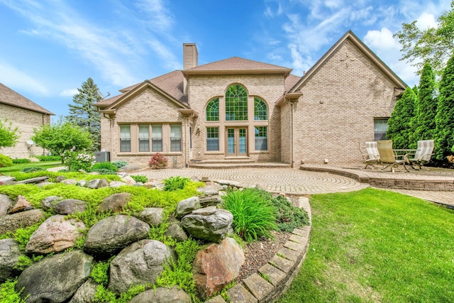 482 Torrington Dr W, Canton, MI 48188 - back of house with a patio area, a chimney, brick siding, french doors, and a yard