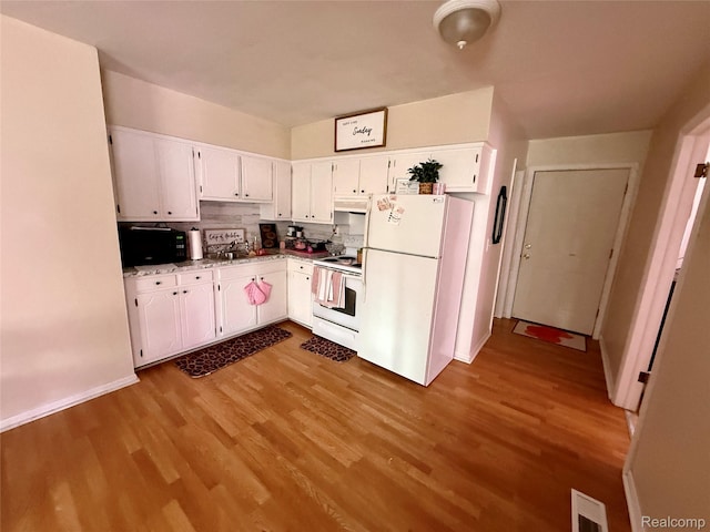 2243 Noble Ave, Flint, MI 48532 - kitchen featuring white appliances, wood finished floors, white cabinets, under cabinet range hood, and baseboards