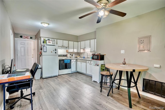 2243 Noble Ave, Flint, MI 48532 - kitchen with white appliances, under cabinet range hood, light countertops, light wood-type flooring, and white cabinets