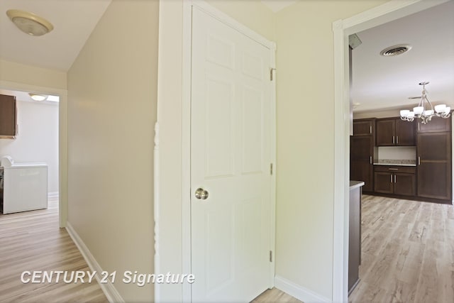 4769 S Fordney Rd, Hemlock, MI 48626 - corridor with light wood-type flooring, a chandelier, and baseboards