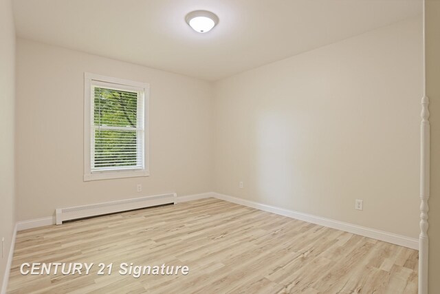 4769 S Fordney Rd, Hemlock, MI 48626 - spare room featuring a baseboard heating unit, wood finished floors, and baseboards