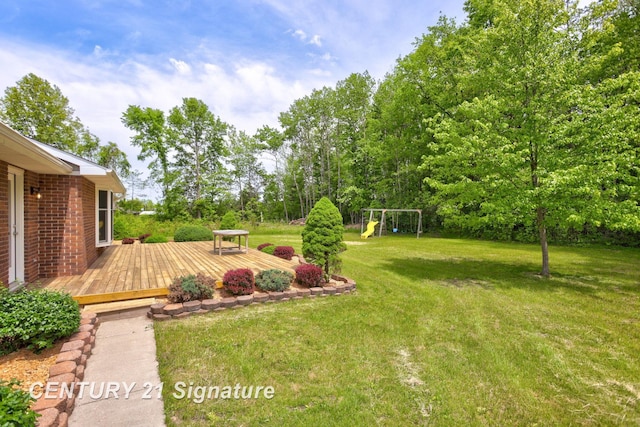 4769 S Fordney Rd, Hemlock, MI 48626 - view of green lawn featuring a wooden deck and a playground