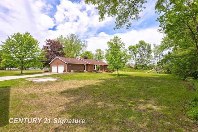 4769 S Fordney Rd, Hemlock, MI 48626 - view of green lawn featuring concrete driveway, a playground, and a garage