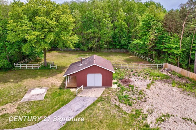 4769 S Fordney Rd, Hemlock, MI 48626 - view of yard featuring a detached garage, a forest view, and an outdoor structure