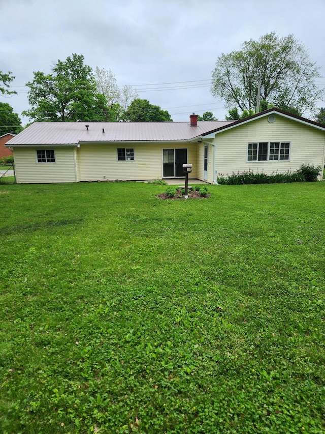 179 W State St, Coldwater, MI 49036 - back of property with a lawn, a chimney, and a metal roof