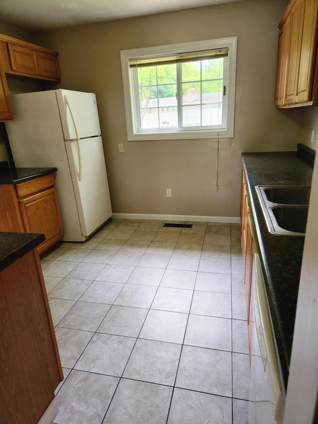 179 W State St, Coldwater, MI 49036 - kitchen with dark countertops, white appliances, brown cabinets, and light tile patterned floors