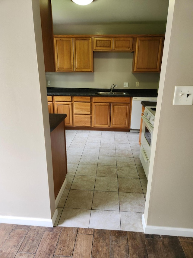 179 W State St, Coldwater, MI 49036 - kitchen featuring white appliances, dark countertops, and brown cabinetry