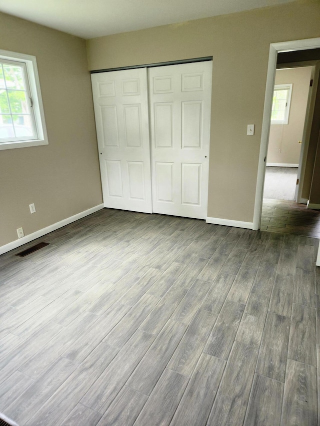 179 W State St, Coldwater, MI 49036 - unfurnished bedroom with dark wood-style flooring and a closet