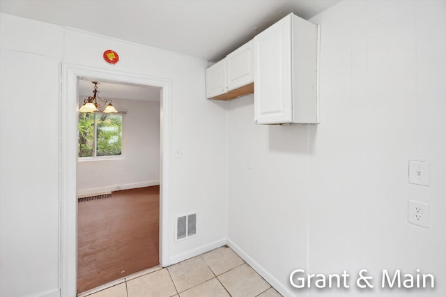 19250 Charest St, Detroit, MI 48234 - laundry room featuring light tile patterned flooring, a chandelier, and baseboards