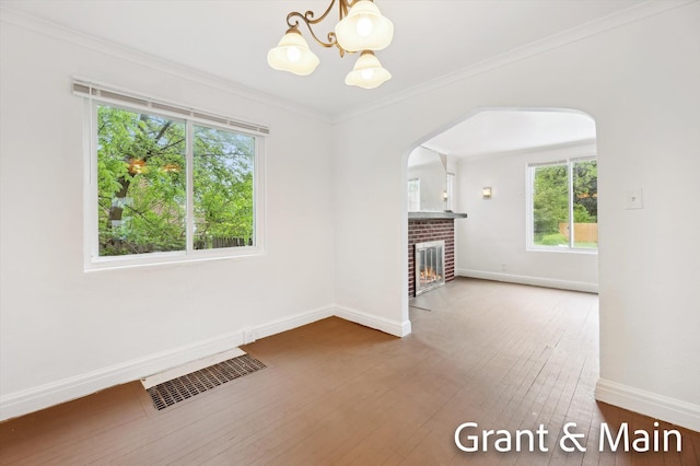19250 Charest St, Detroit, MI 48234 - unfurnished living room featuring healthy amount of natural light, a chandelier, baseboards, arched walkways, and crown molding