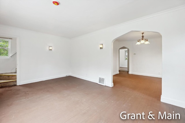 19250 Charest St, Detroit, MI 48234 - spare room with arched walkways, wood-type flooring, baseboards, crown molding, and a chandelier