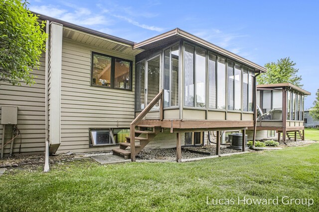 8535 Elkwood Dr SW, Byron Center, MI 49315 - back of house with a sunroom, central AC unit, a lawn, and stairway