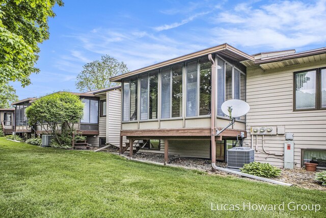 8535 Elkwood Dr SW, Byron Center, MI 49315 - rear view of house featuring a sunroom, a lawn, and cooling unit