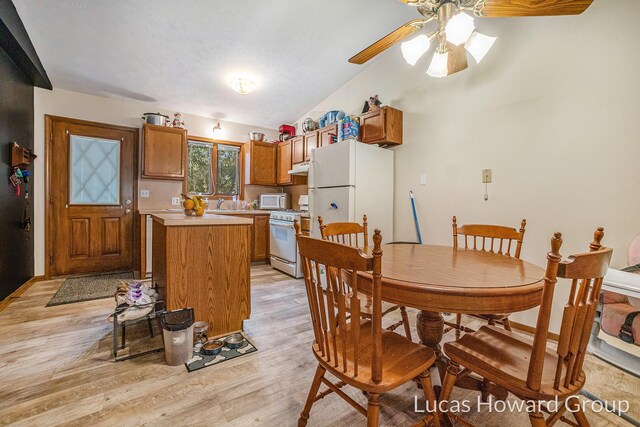 8535 Elkwood Dr SW, Byron Center, MI 49315 - dining space with light wood-style flooring, a ceiling fan, and lofted ceiling