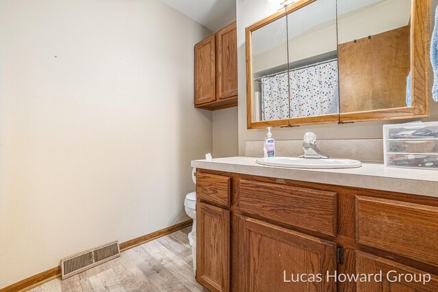 8535 Elkwood Dr SW, Byron Center, MI 49315 - full bathroom featuring vanity, toilet, baseboards, and wood finished floors